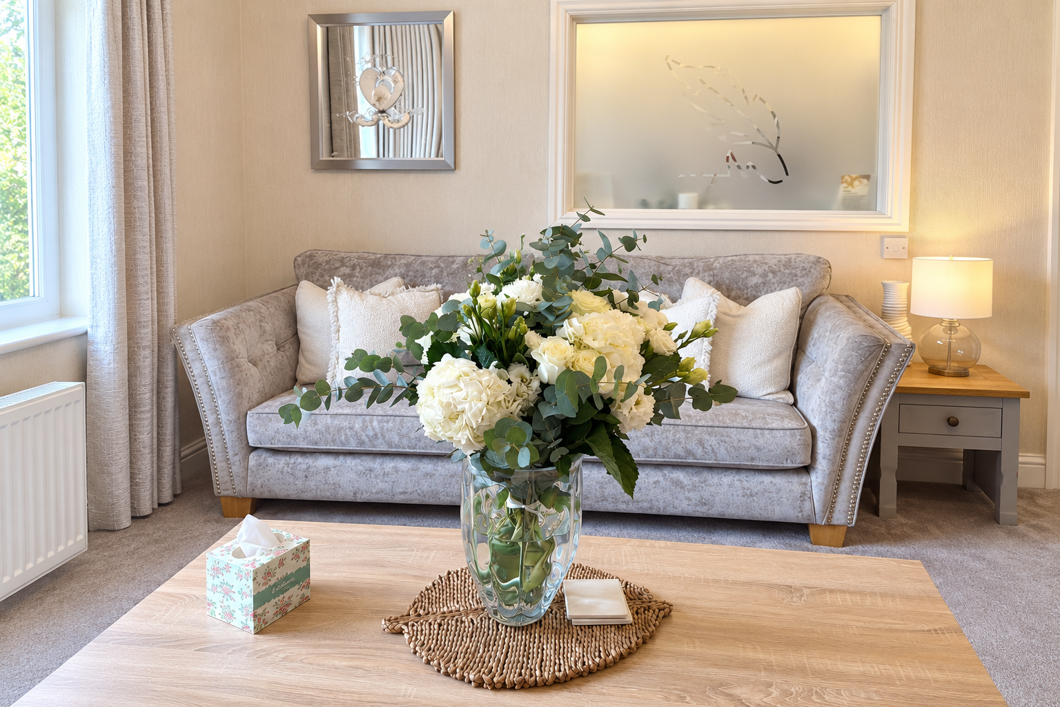 White flowers and eucalyptus in a glass vase in the Hope Funeral Care lounge